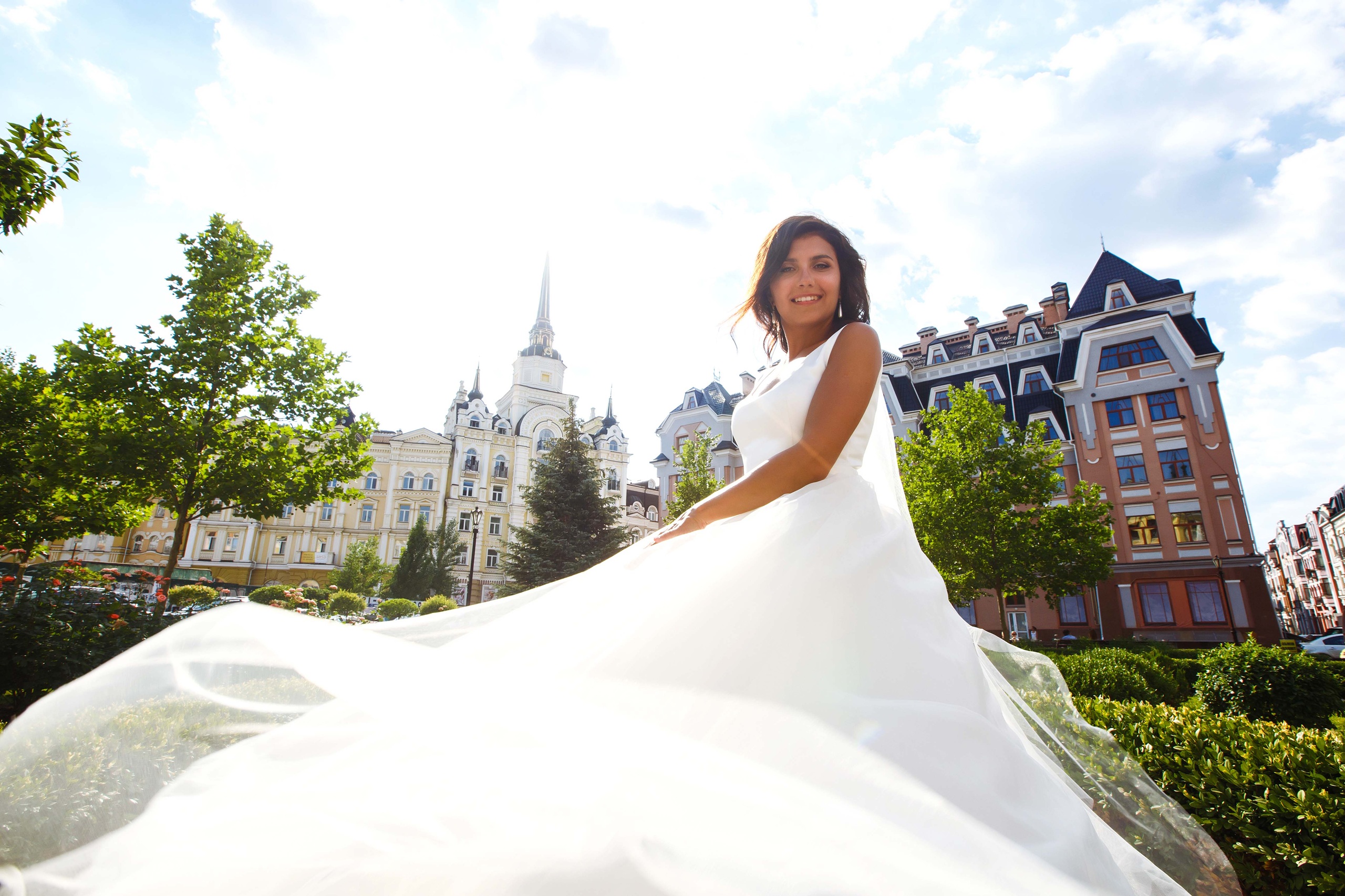 Bride posing in the sun with wedding dress on.