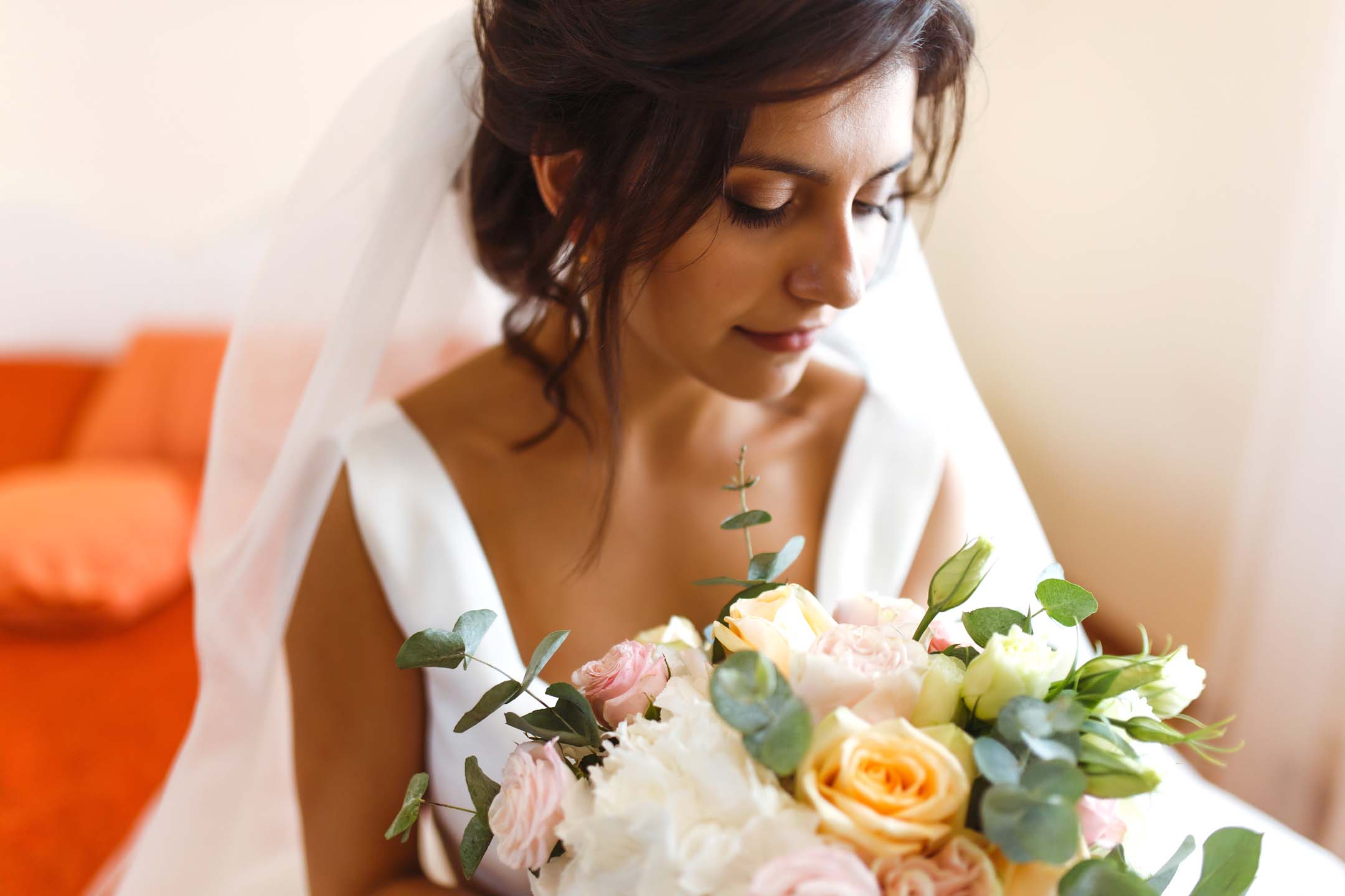 Up close shot of bride in white dress with bouquet.