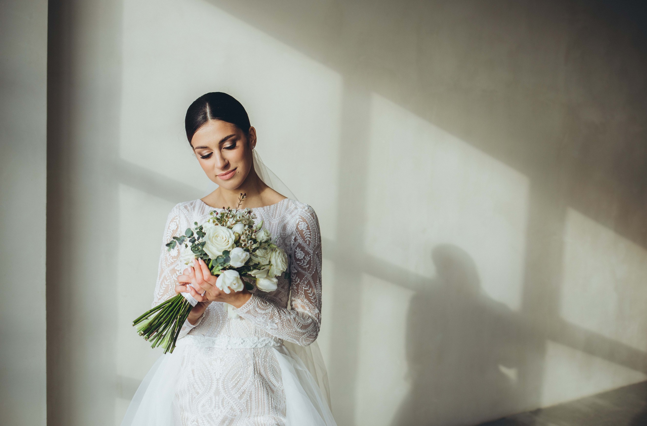 A bride in a white wedding dress holding a bouquet of flowers.