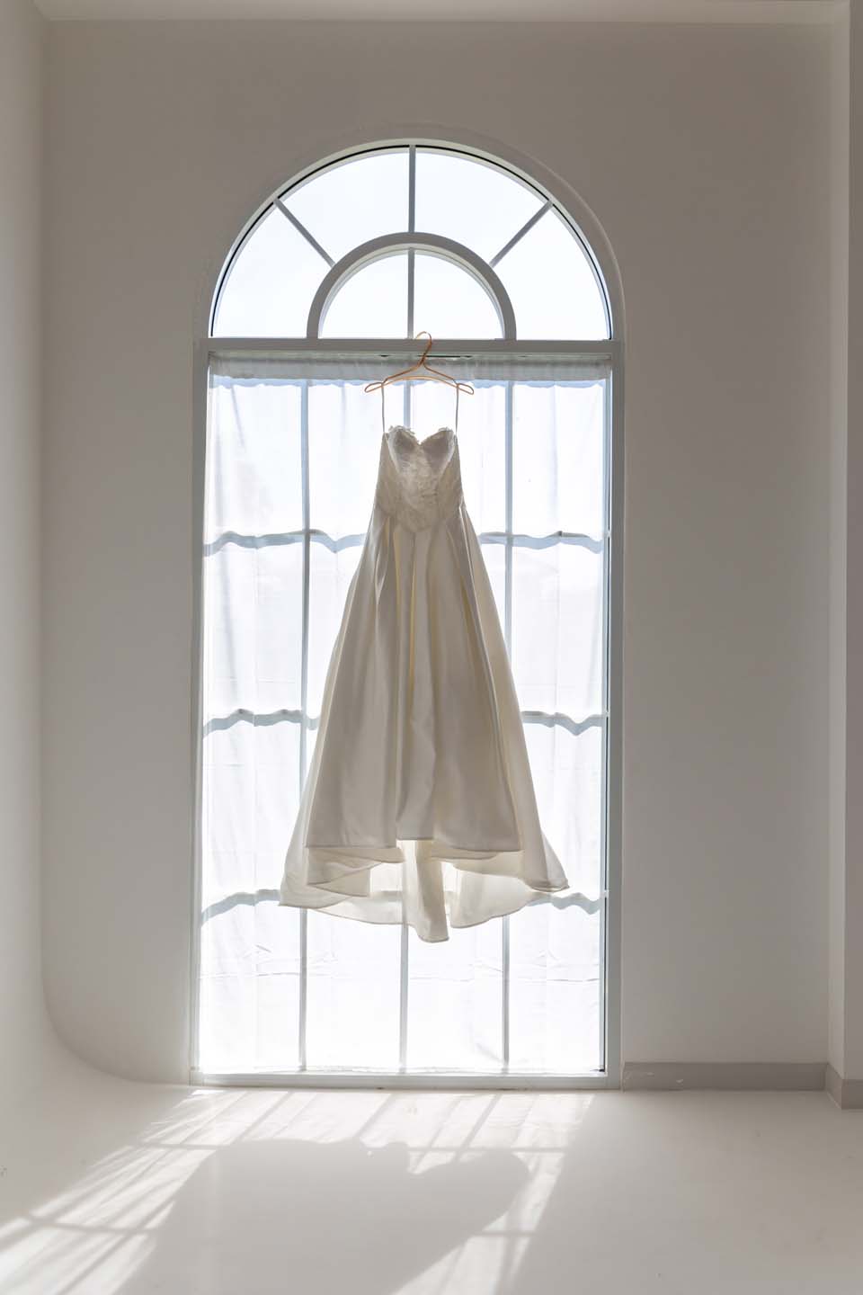 White dress hanging in the window.